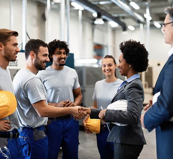 Factory workers shaking hands